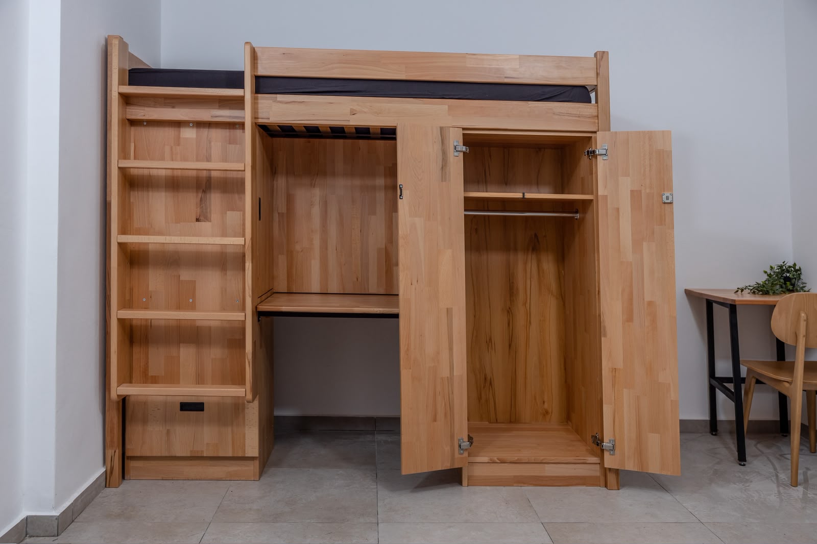 Natural wood loft bed, desk and wardrobe system in a student room