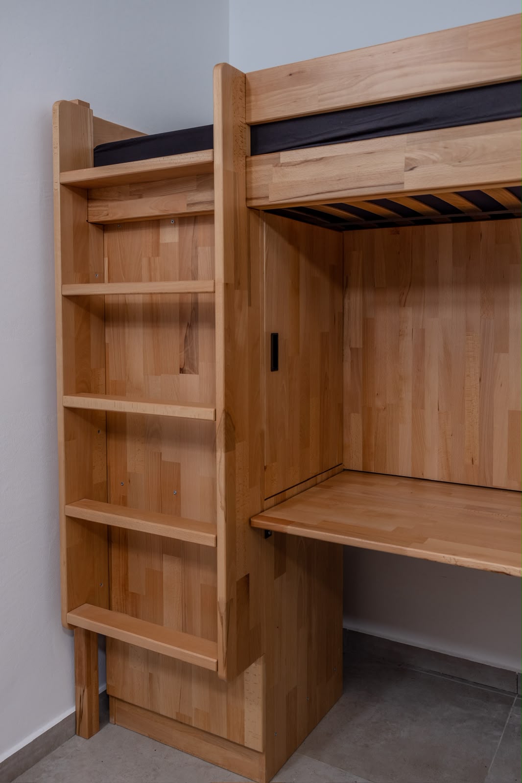 Natural wood shelving and study desk below a loft bed