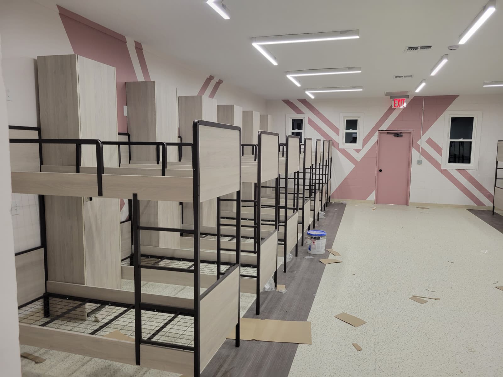 Two-tone bunk beds arranged for a yeshiva dormitory room