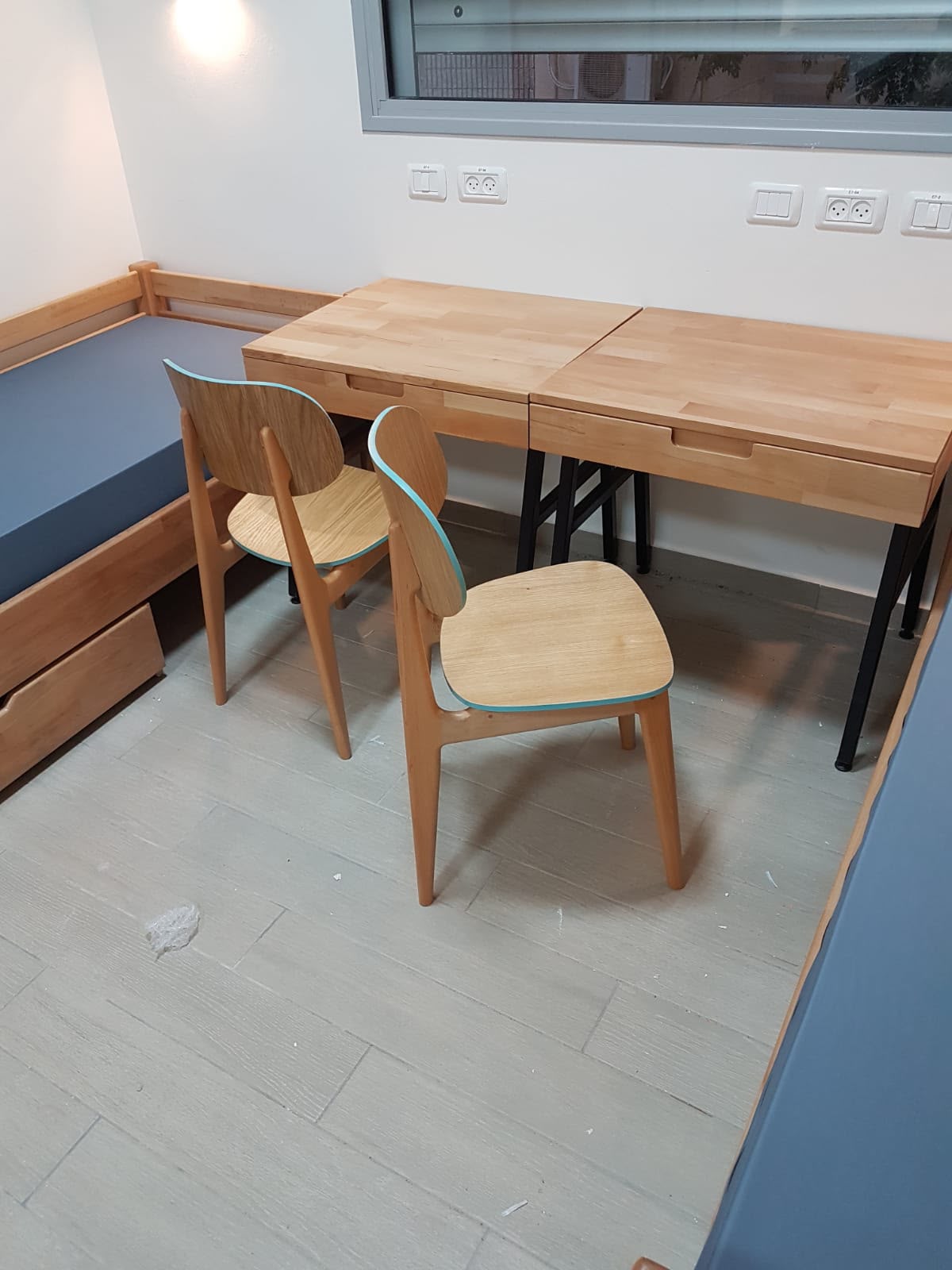 Warm wood study table for a yeshiva dormitory room